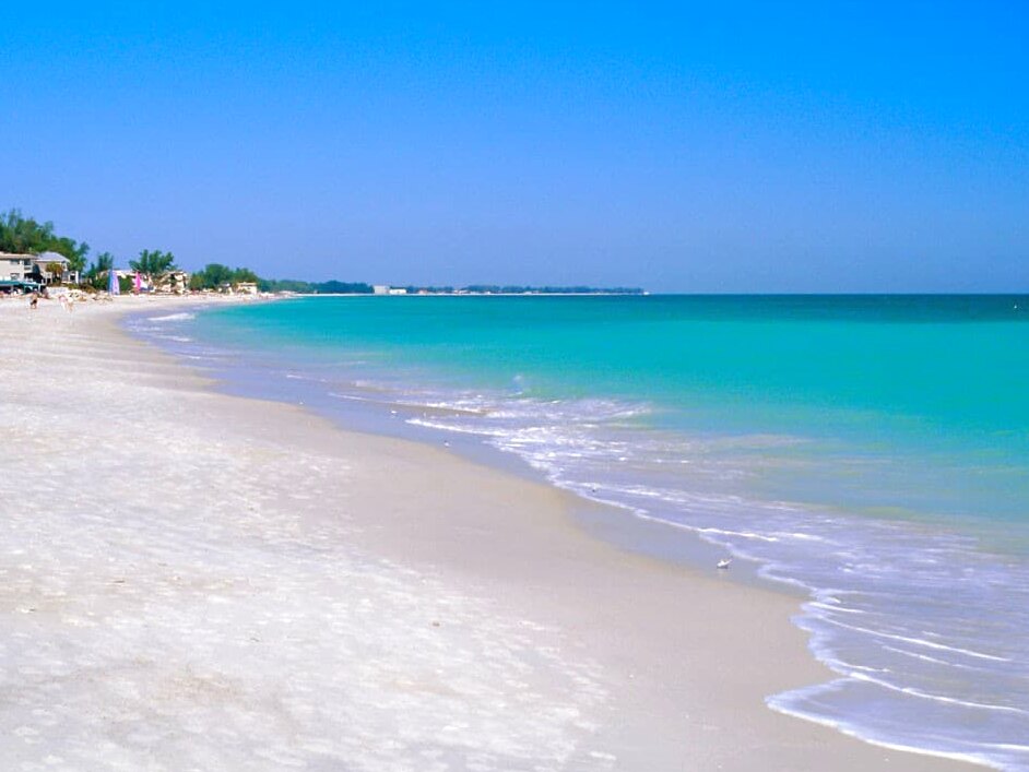 An all-white beach wedding ceremony among the sea oats