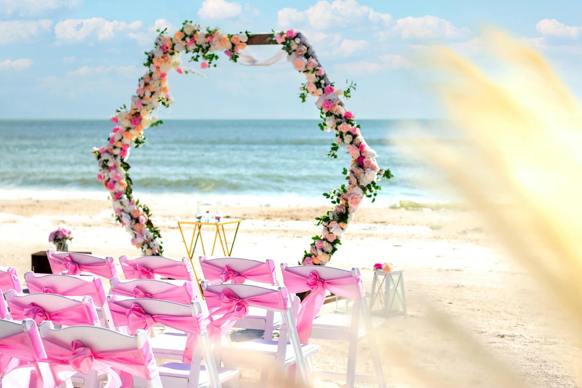 A fresh-flower wedding arch being designed on the beach