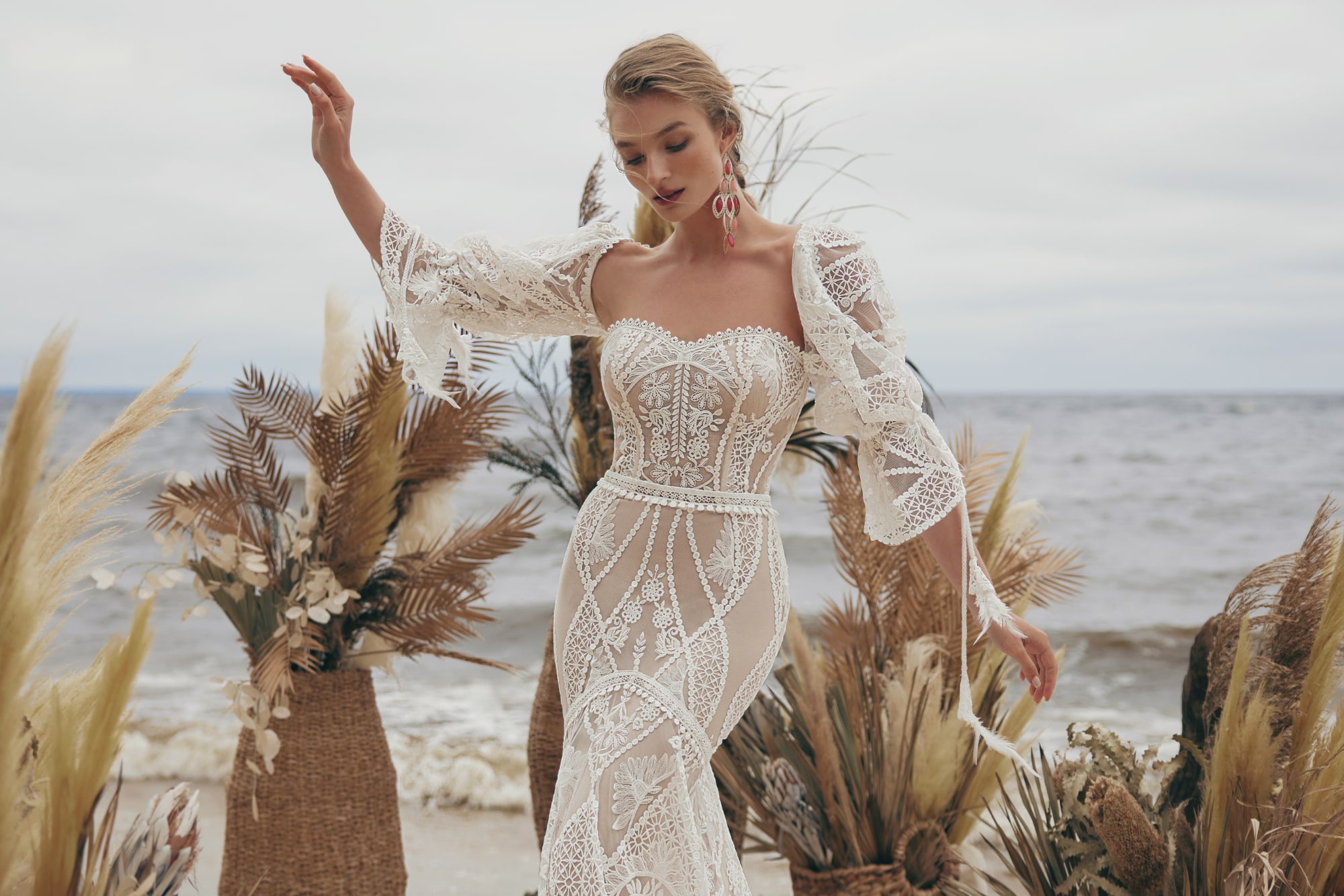Editorial bride with pampas and dried palms on the shore at dusk